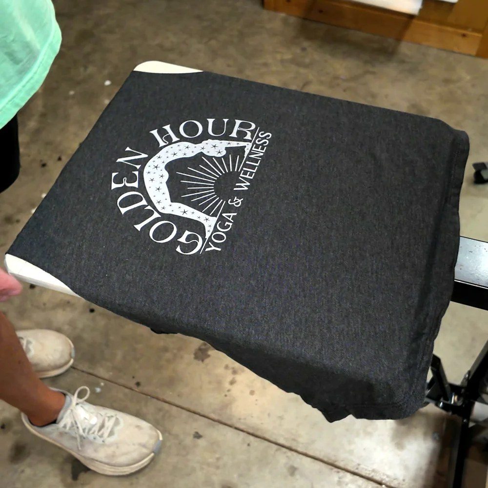 Charcoal T-shirt printed with the Golden Hour Yoga & Wellness logo